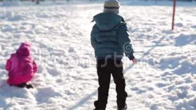 孩子们在阳光明媚的冬天在雪地里散步。 男孩在雪地里奔跑